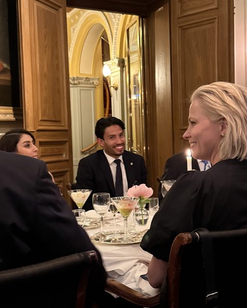 Colleagues talking around a candlelit dinner table.