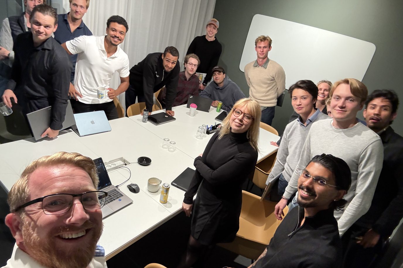 The Neuro team gathered around a long table in the Stockholm office, looking up towards the camera.